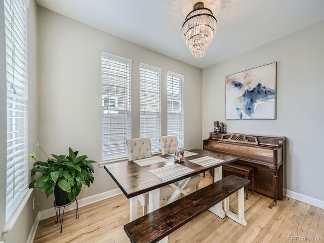 dining area featuring light hardwood / wood-style floors and a notable chandelier