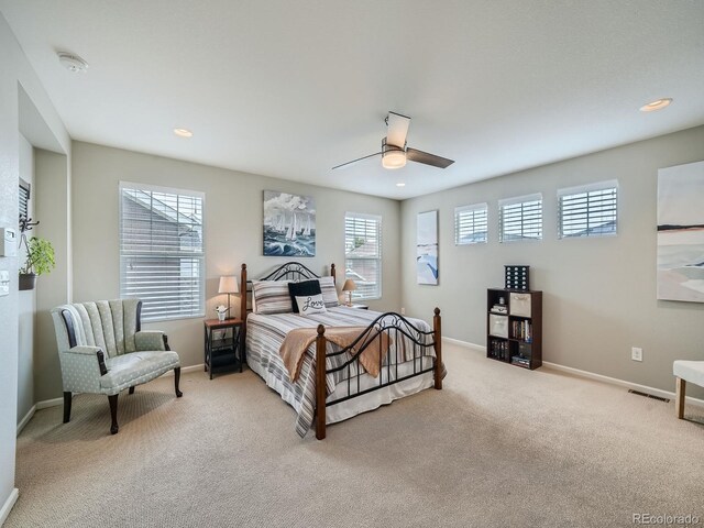 bedroom with multiple windows, ceiling fan, and light colored carpet