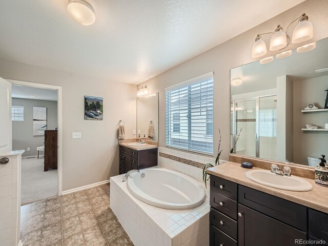 bathroom with tile patterned flooring, independent shower and bath, and vanity