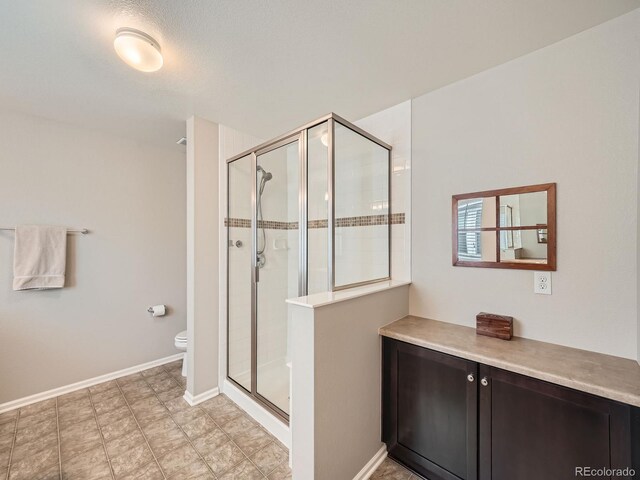 bathroom featuring toilet and a shower with shower door