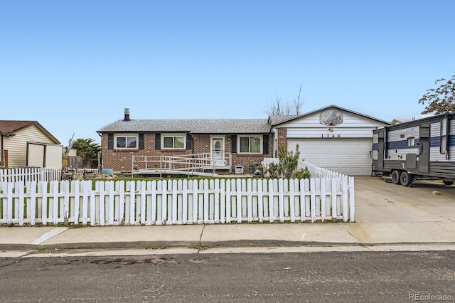 ranch-style home featuring a garage, a fenced front yard, brick siding, and concrete driveway
