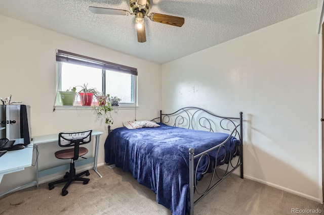 carpeted bedroom with a textured ceiling, baseboards, and ceiling fan