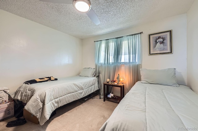 bedroom featuring a textured ceiling, carpet floors, and a ceiling fan