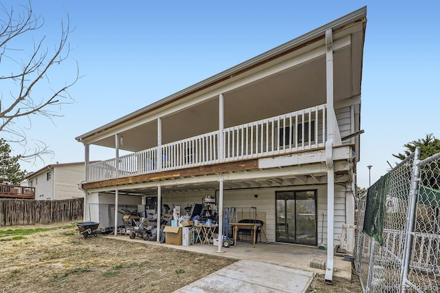 rear view of property featuring fence and a patio
