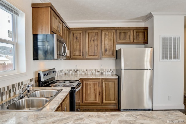 kitchen featuring crown molding, sink, a healthy amount of sunlight, and appliances with stainless steel finishes