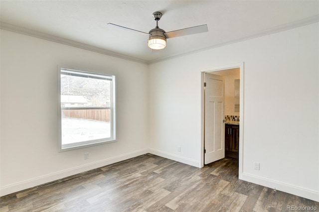 spare room featuring ceiling fan, crown molding, and dark wood-type flooring