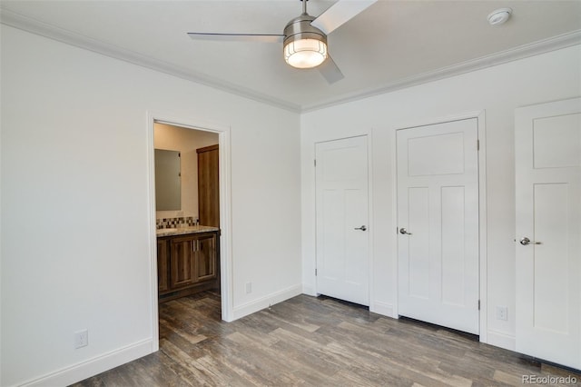 unfurnished bedroom featuring dark hardwood / wood-style flooring, ceiling fan, ornamental molding, and connected bathroom