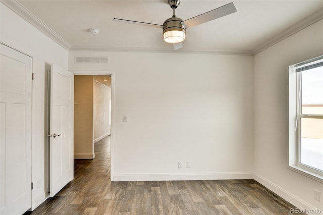 unfurnished room with dark wood-type flooring, plenty of natural light, ceiling fan, and ornamental molding