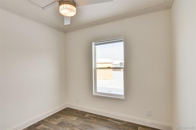 empty room with dark wood-type flooring, a healthy amount of sunlight, and ornamental molding