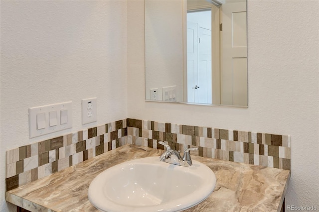 bathroom with decorative backsplash and sink