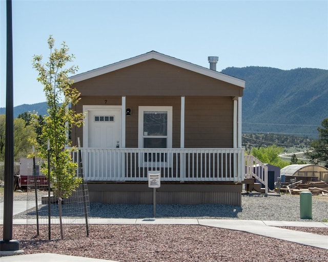 manufactured / mobile home featuring a mountain view and covered porch