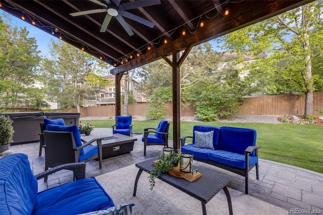 view of patio / terrace with a hot tub, an outdoor living space with a fire pit, and a ceiling fan