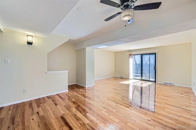 unfurnished room featuring wood finished floors, visible vents, and baseboards