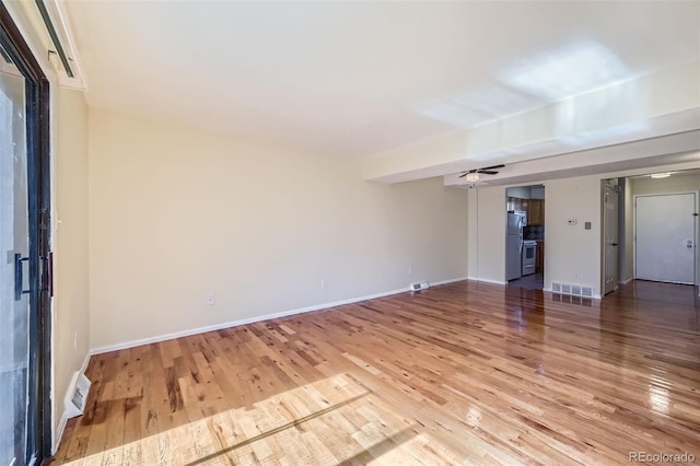 unfurnished room featuring ceiling fan, wood finished floors, and baseboards