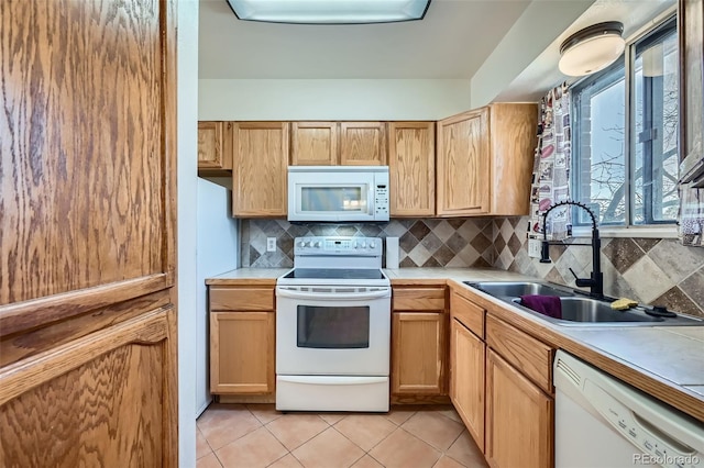 kitchen featuring light tile patterned floors, white appliances, a sink, light countertops, and tasteful backsplash