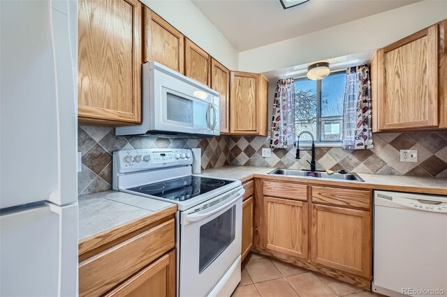 kitchen featuring white appliances, tasteful backsplash, light tile patterned floors, tile countertops, and a sink