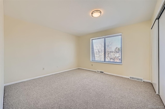 unfurnished bedroom with carpet, a closet, visible vents, and baseboards