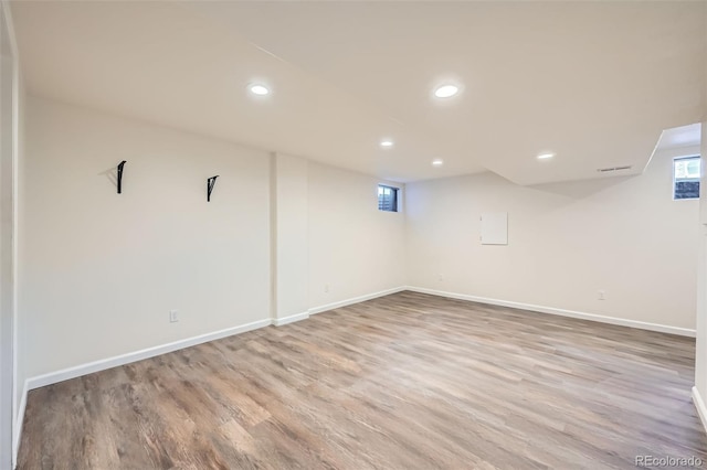 basement with baseboards, wood finished floors, and recessed lighting