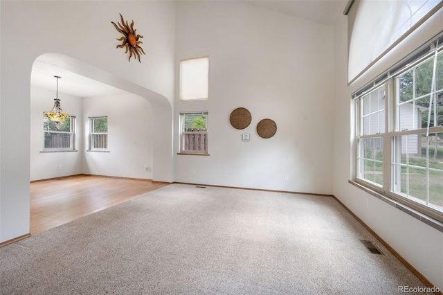 2859 Front Royal Dr, Colorado Springs, CO 80919 - unfurnished room with light colored carpet, a towering ceiling, and arched walkways
