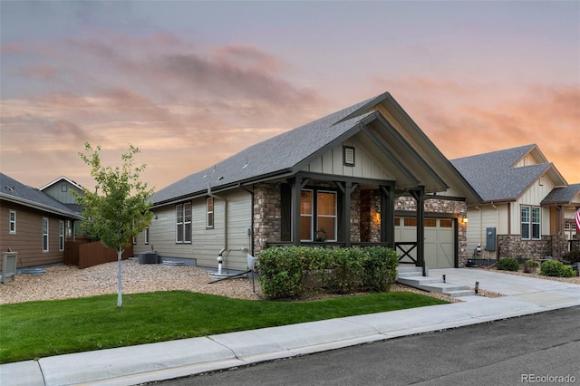 view of front of house featuring driveway, stone siding, a porch, and board and batten siding