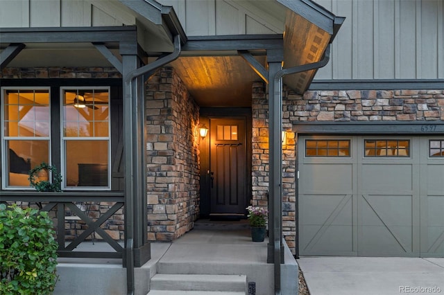 property entrance with an attached garage, stone siding, and board and batten siding