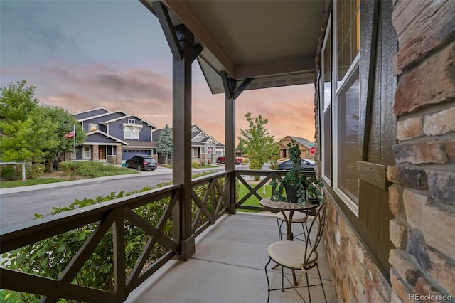 balcony at dusk with a porch and a residential view