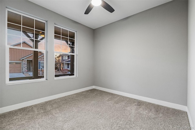 empty room with ceiling fan, carpet floors, and baseboards