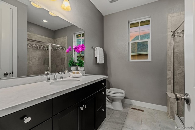 full bathroom featuring toilet, visible vents, vanity, baseboards, and a shower stall