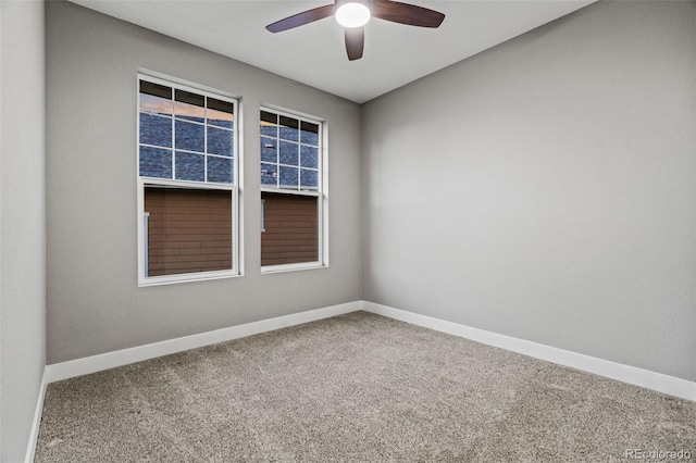 carpeted empty room featuring ceiling fan and baseboards