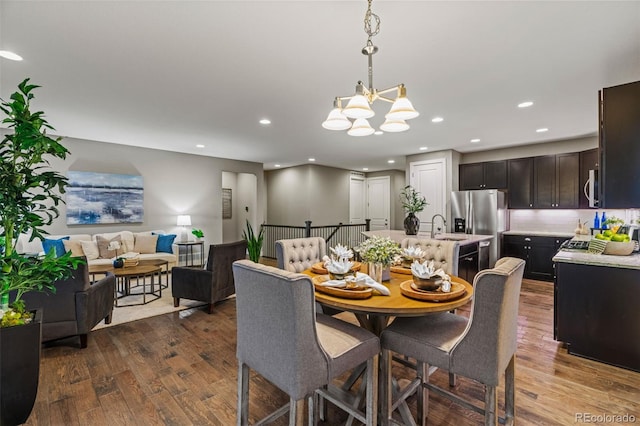 dining room with a chandelier, dark wood-type flooring, and recessed lighting