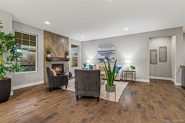 living area featuring recessed lighting, a large fireplace, baseboards, and wood finished floors