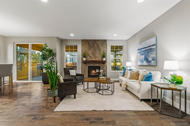 living room featuring recessed lighting, a fireplace, wood finished floors, visible vents, and baseboards