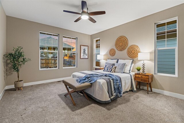 carpeted bedroom with ceiling fan and baseboards