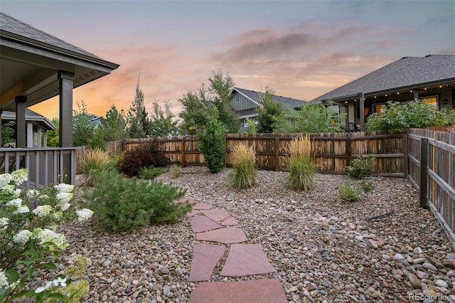 yard at dusk with a fenced backyard