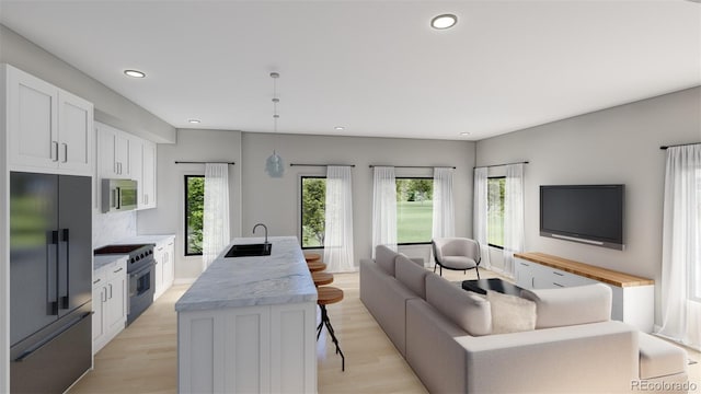 living room featuring sink, a healthy amount of sunlight, and light hardwood / wood-style flooring