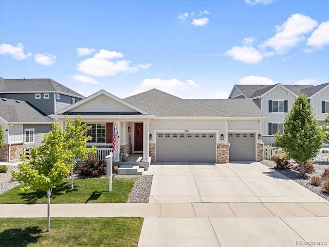7074 S Vandriver Ct, Aurora, CO 80016 - view of front facade featuring a garage, covered porch, concrete driveway, stone siding, and a front lawn