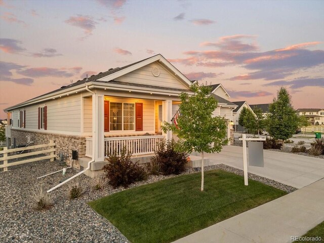 7074 S Vandriver Ct, Aurora, CO 80016 - view of front of house featuring a porch, an attached garage, and stone siding