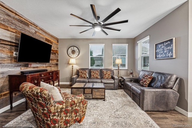 living room with a textured ceiling, dark hardwood / wood-style flooring, and ceiling fan