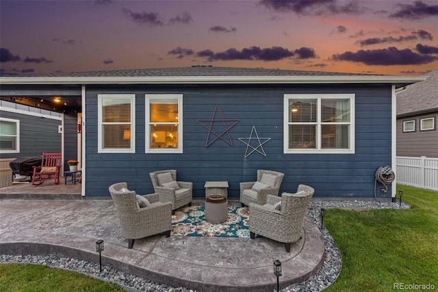 back house at dusk with a patio area