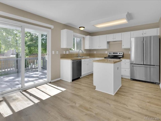 8906 Miners Dr, Highlands Ranch, CO 80126 - kitchen with stainless steel appliances, light countertops, white cabinetry, light wood finished floors, and a center island
