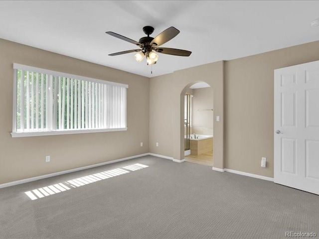 8906 Miners Dr, Highlands Ranch, CO 80126 - unfurnished bedroom featuring arched walkways, carpet floors, ensuite bath, and ceiling fan