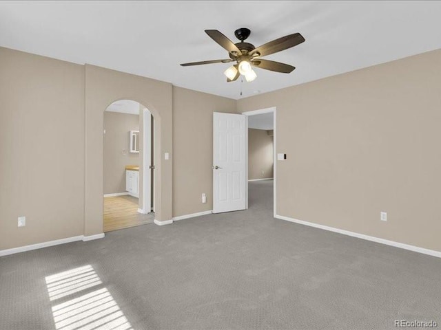 8906 Miners Dr, Highlands Ranch, CO 80126 - unfurnished bedroom featuring arched walkways, carpet floors, ensuite bath, and ceiling fan