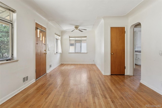 1585 S University Blvd, Denver, CO 80210 - empty room featuring arched walkways, ceiling fan, light wood-type flooring, and healthy amount of natural light