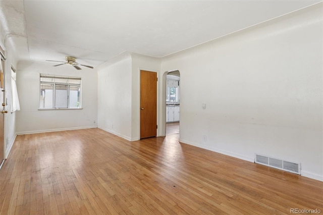 1585 S University Blvd, Denver, CO 80210 - empty room featuring arched walkways, a ceiling fan, and light wood-style flooring