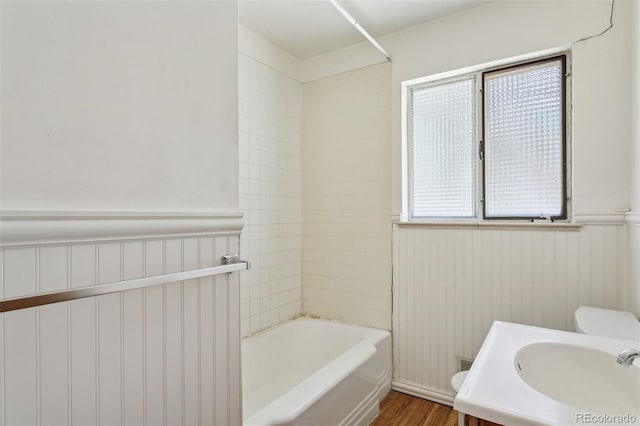 1585 S University Blvd, Denver, CO 80210 - full bath with wood finished floors, vanity, washtub / shower combination, and wainscoting