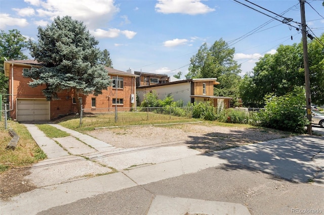 1585 S University Blvd, Denver, CO 80210 - view of front of property featuring a fenced front yard, an attached garage, driveway, and brick siding
