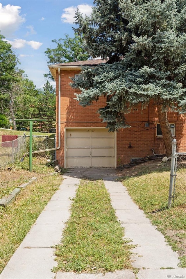 1585 S University Blvd, Denver, CO 80210 - view of side of property with driveway, an attached garage, and brick siding