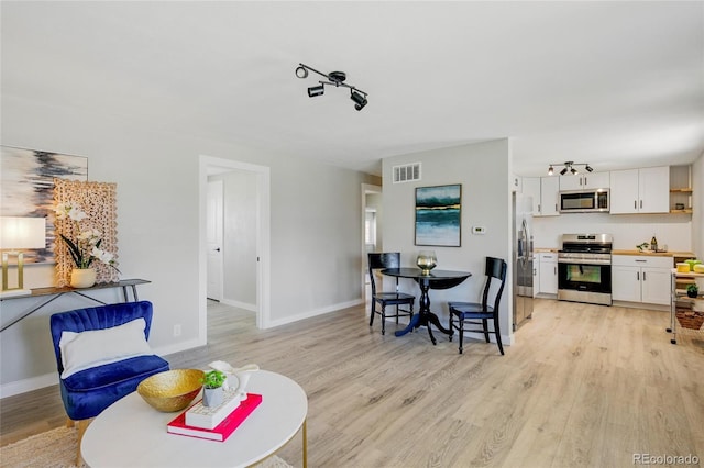 dining area featuring light wood-type flooring and baseboards