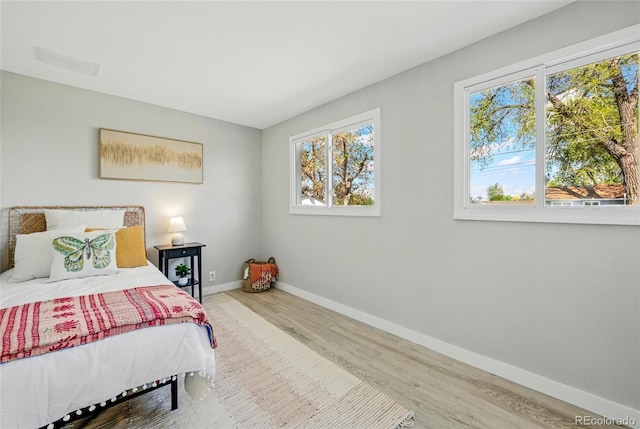 bedroom with baseboards and wood finished floors