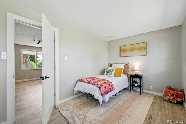 bedroom featuring wood finished floors and baseboards